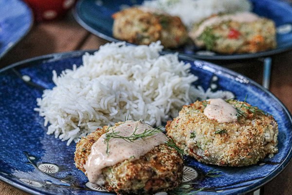 Two plates with rice and tuna cakes on them